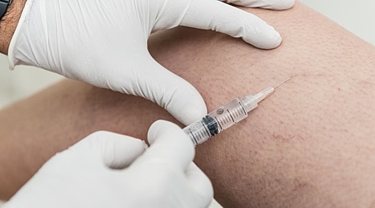 Person receiving injection in leg.