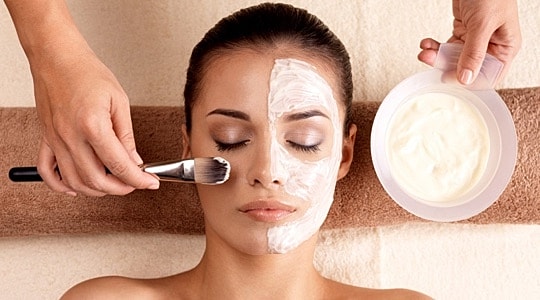 Woman receiving a facial treatment at a spa.
