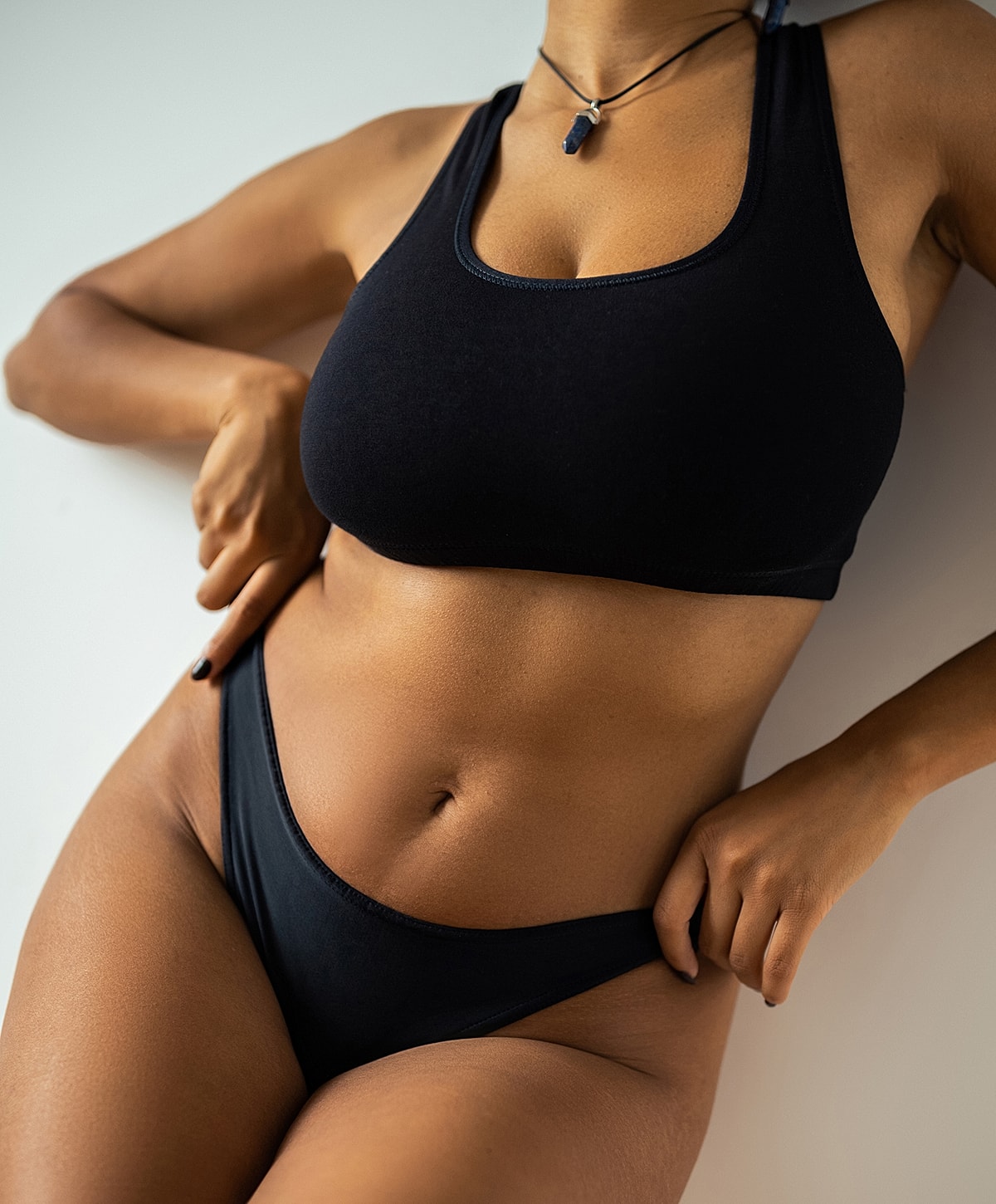 Model in black swimwear, showcasing body confidence.