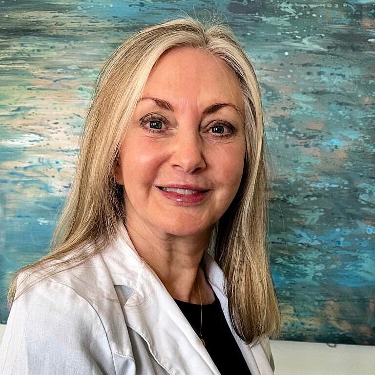 Smiling woman in a white coat, abstract background.