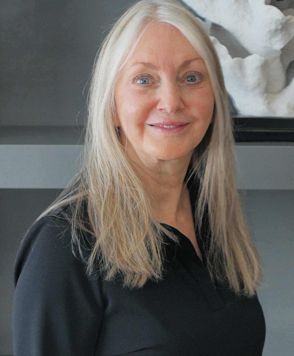 Smiling woman with long blonde hair and black shirt.