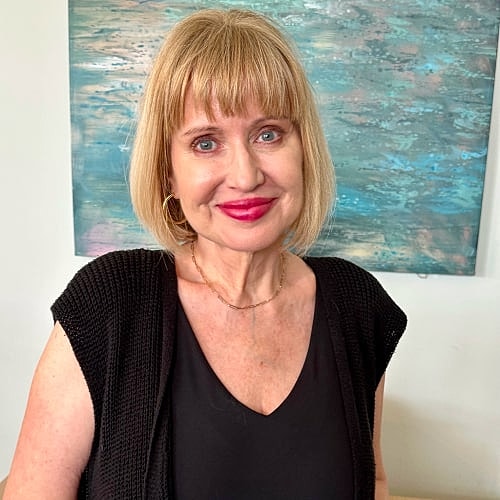 Smiling woman with blonde hair and bright lipstick.