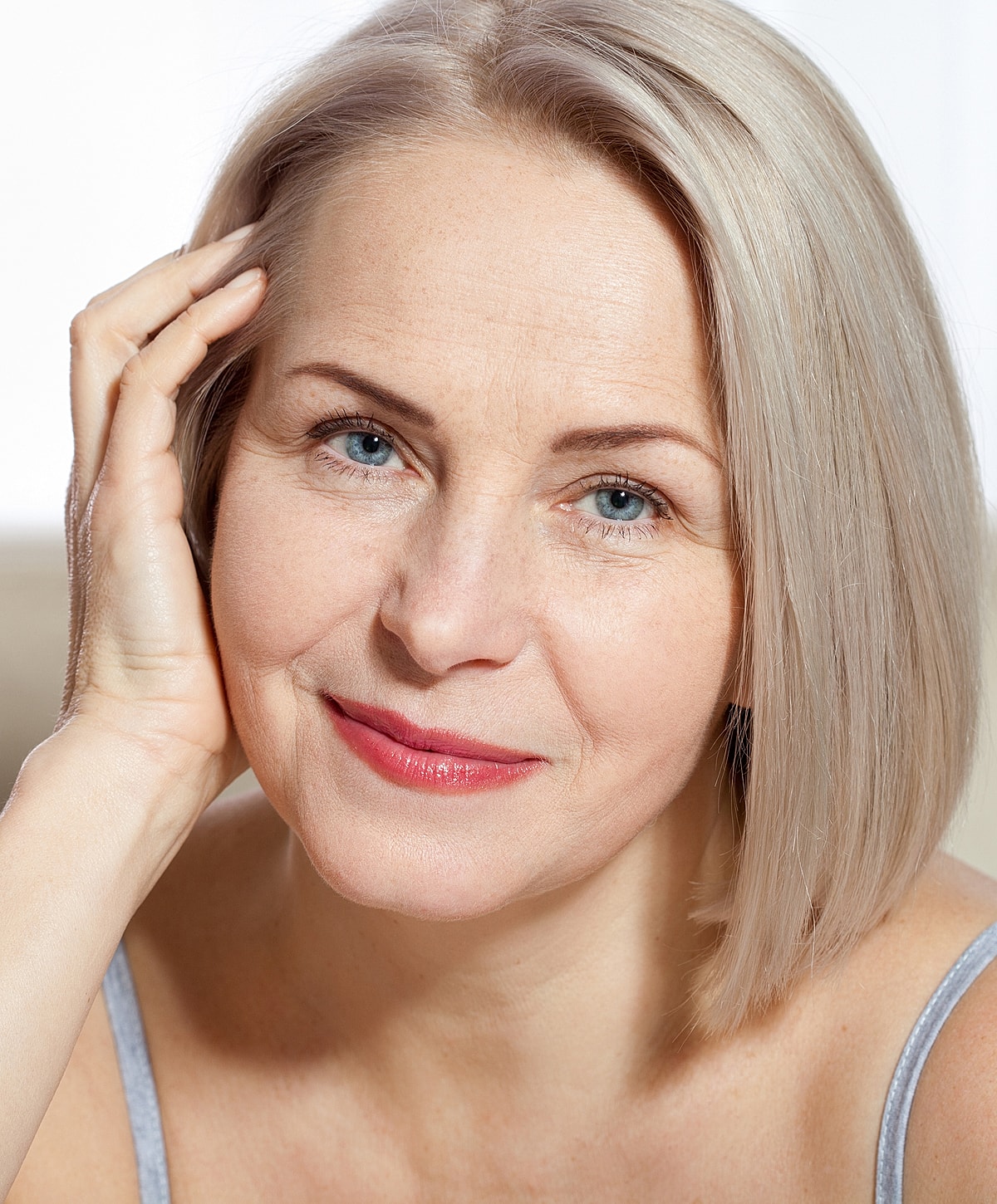 Smiling woman with short blonde hair, natural light.