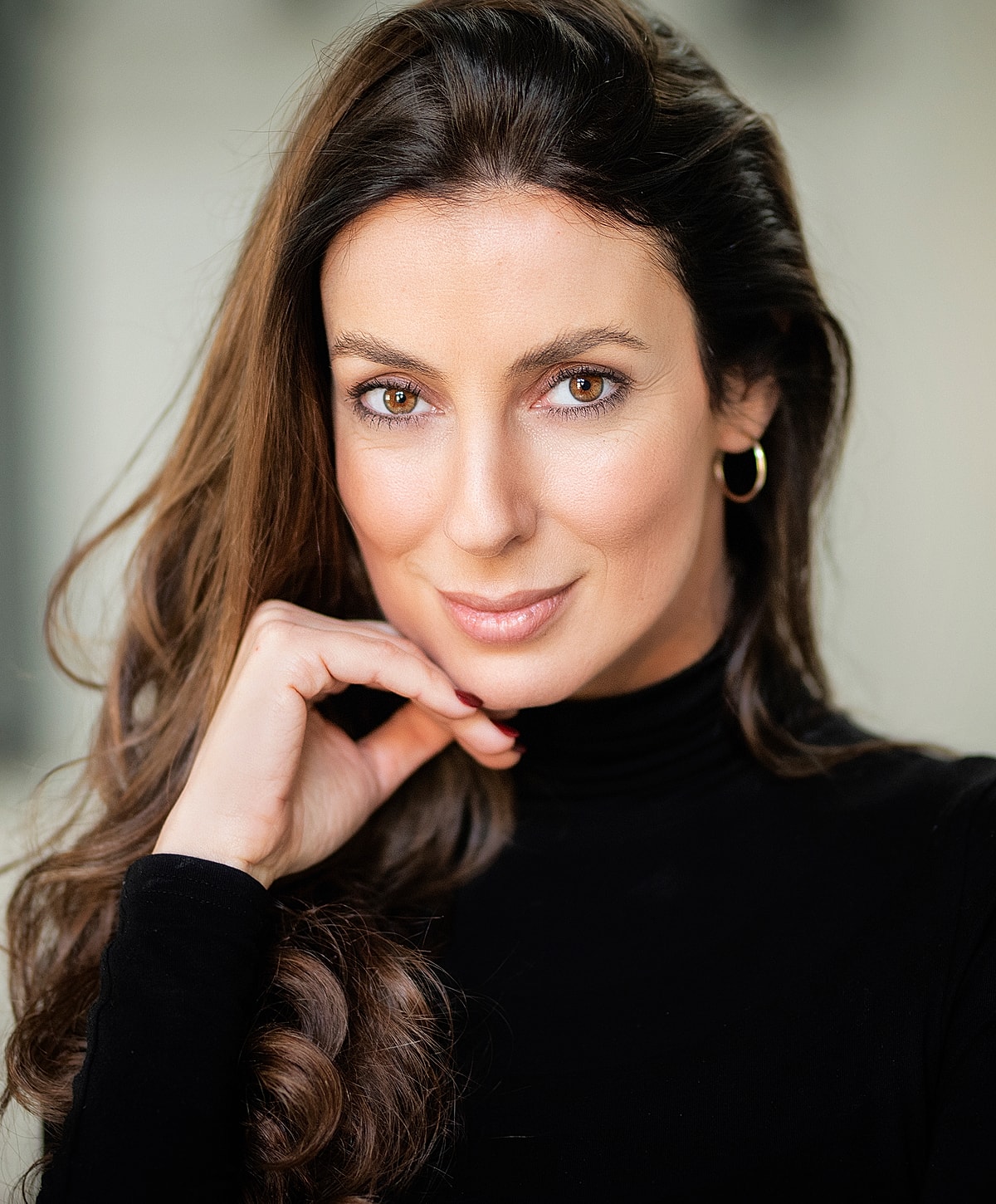 Woman with long hair in black turtleneck.