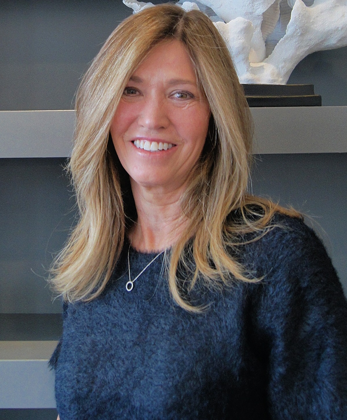 Smiling woman with long hair in casual sweater.