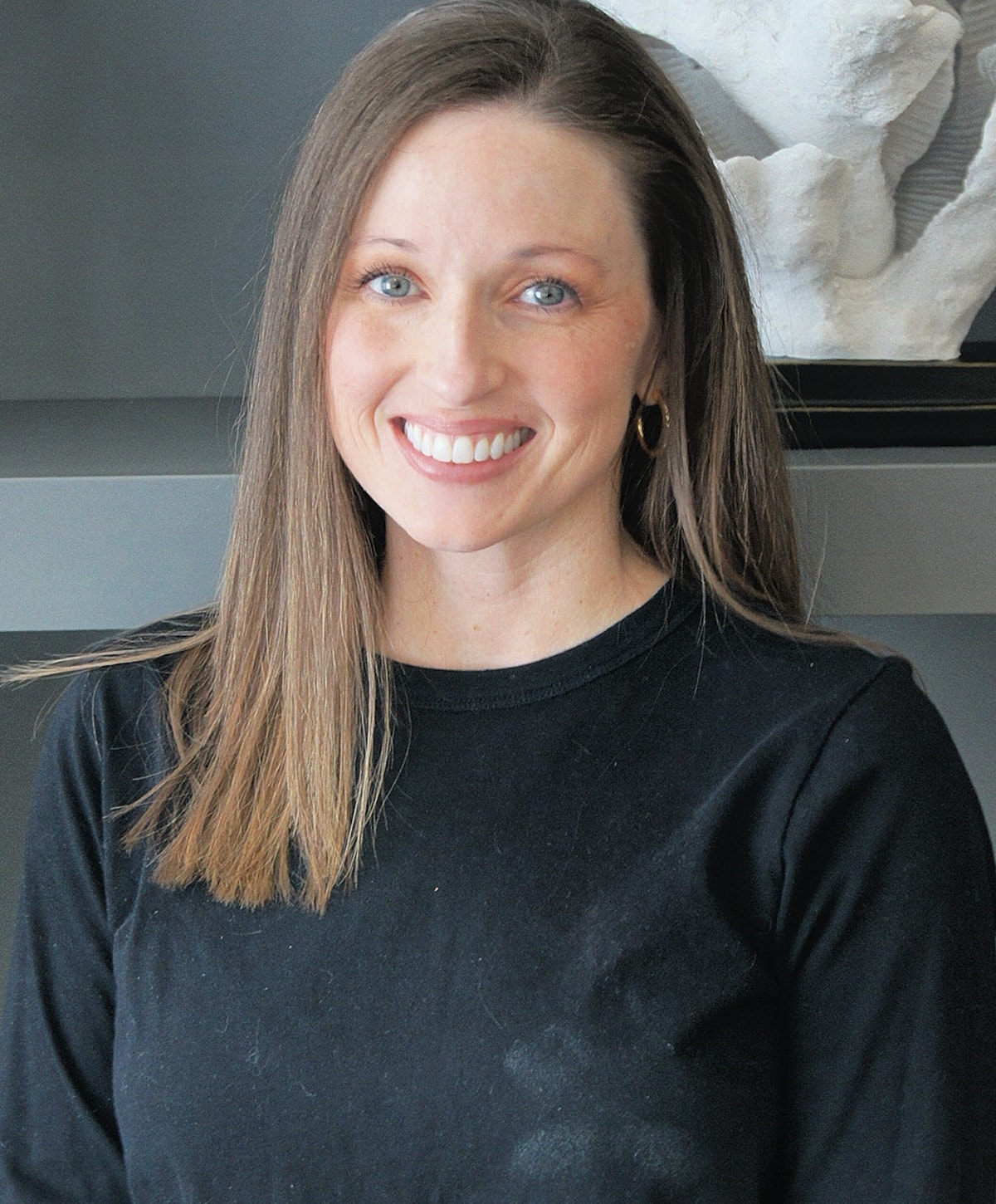 Smiling woman in black shirt, indoor setting.