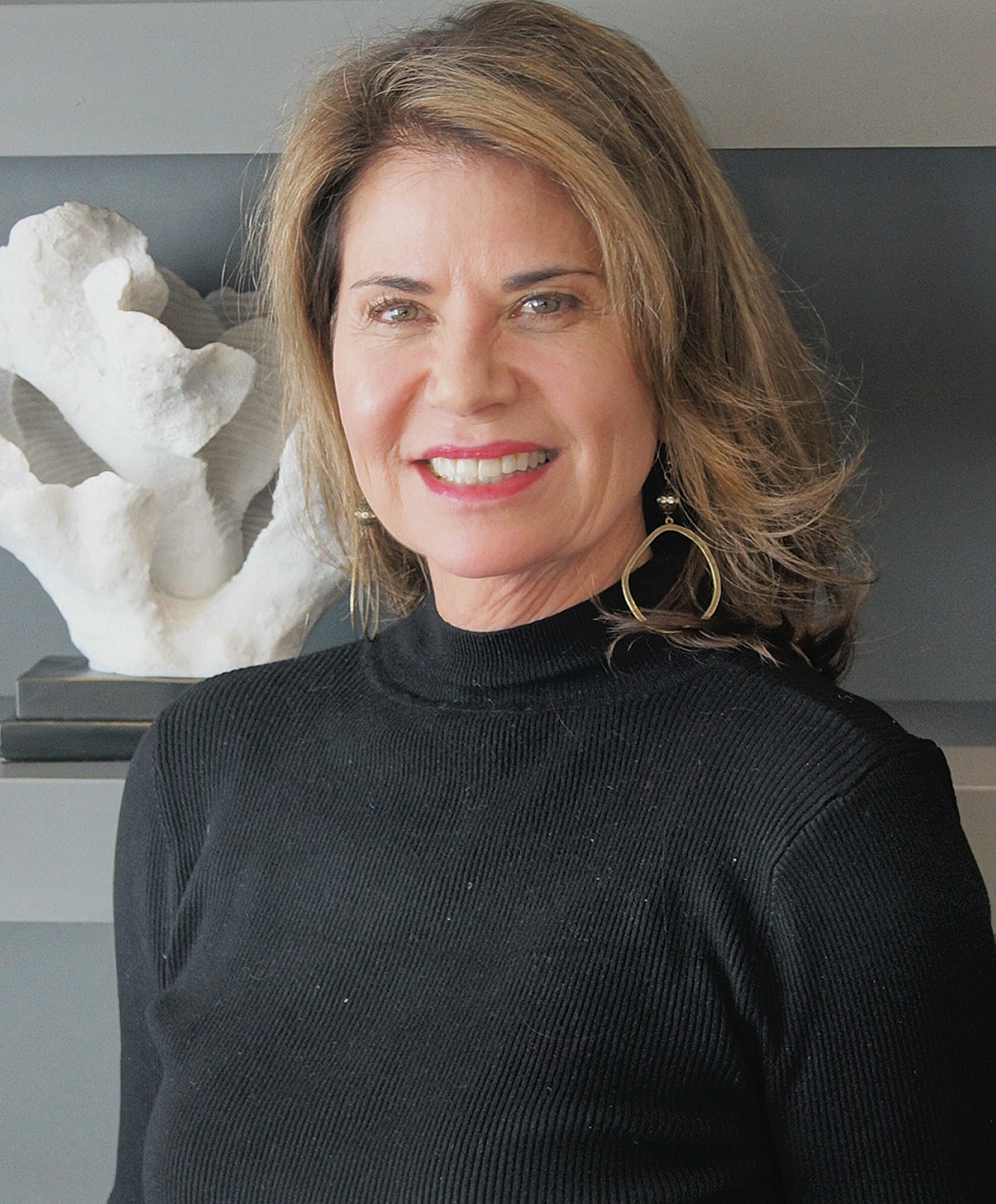 Smiling woman in black turtleneck sweater.