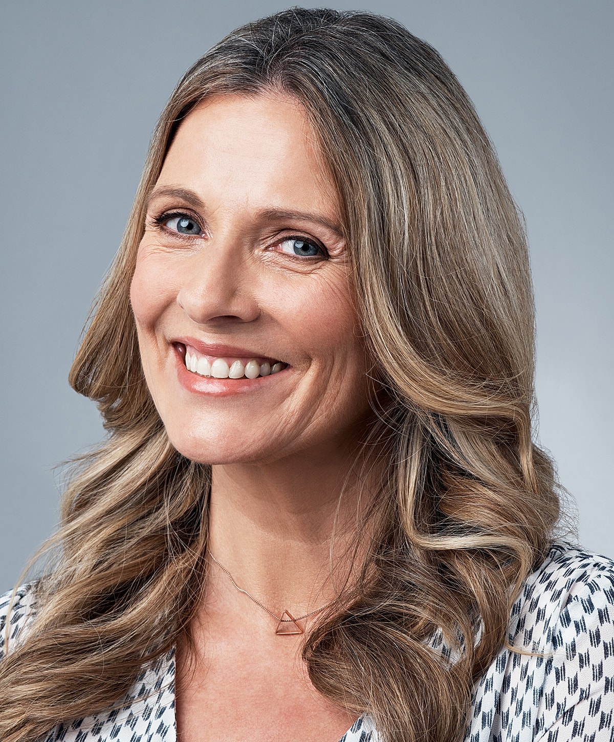 Smiling woman with long, wavy hair.