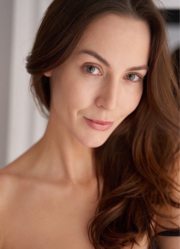 Smiling woman with long hair in black outfit.