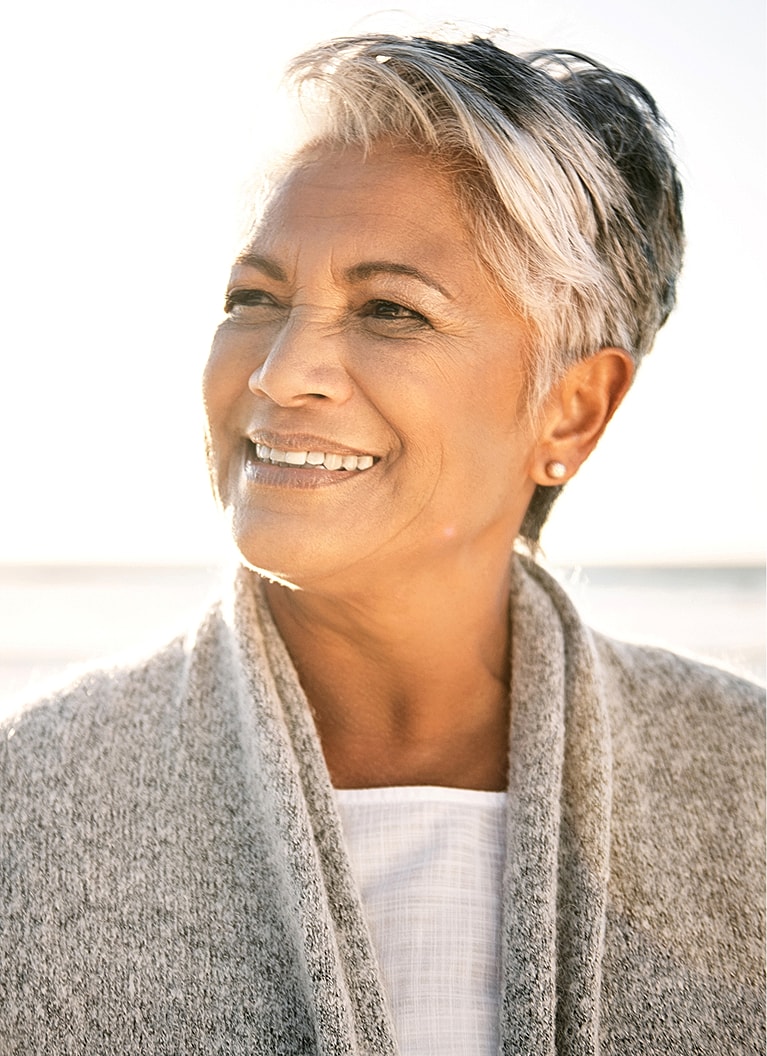 Smiling woman with short gray hair outdoors.