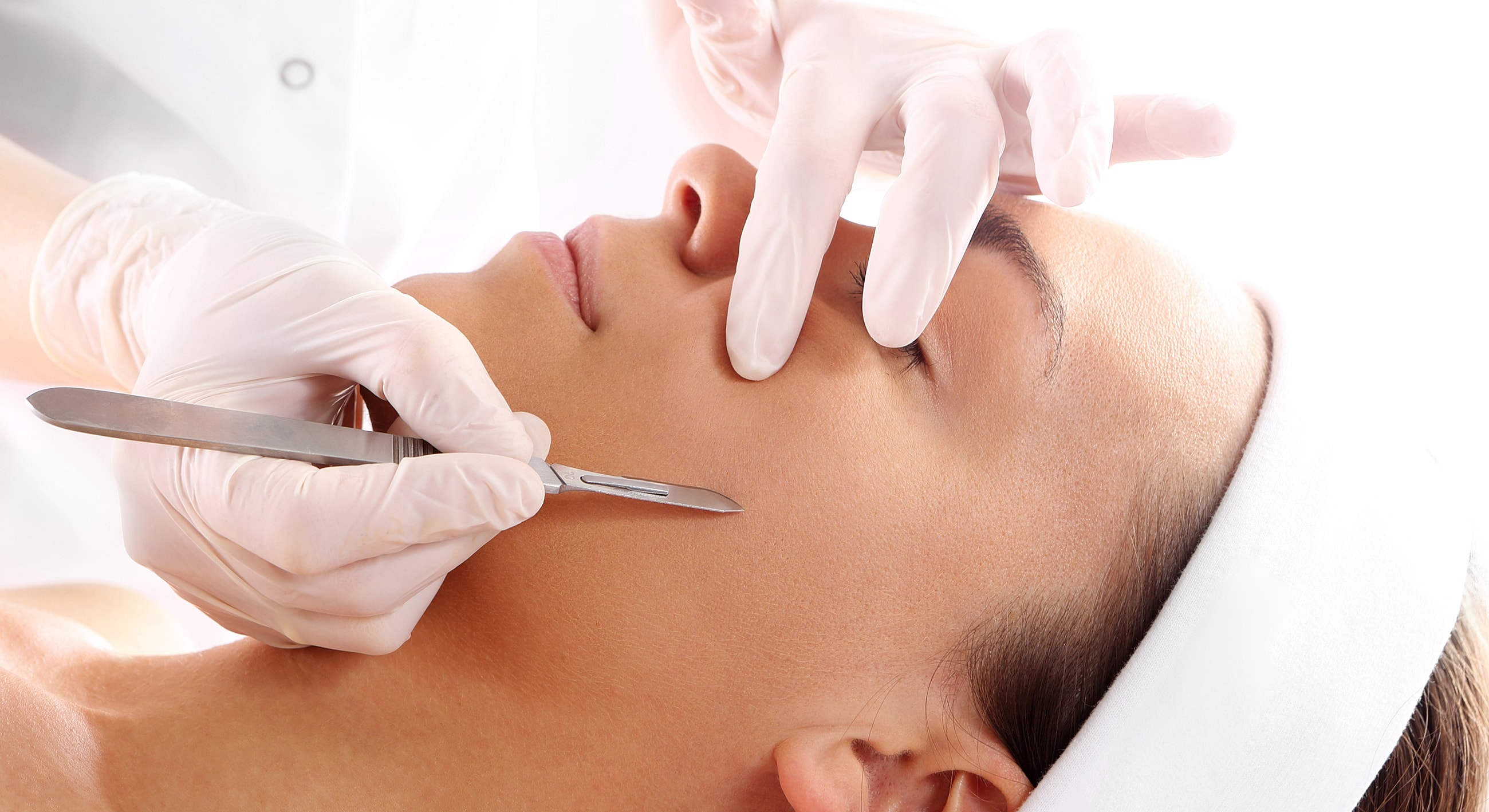 Facial treatment using a scalpel by professional.