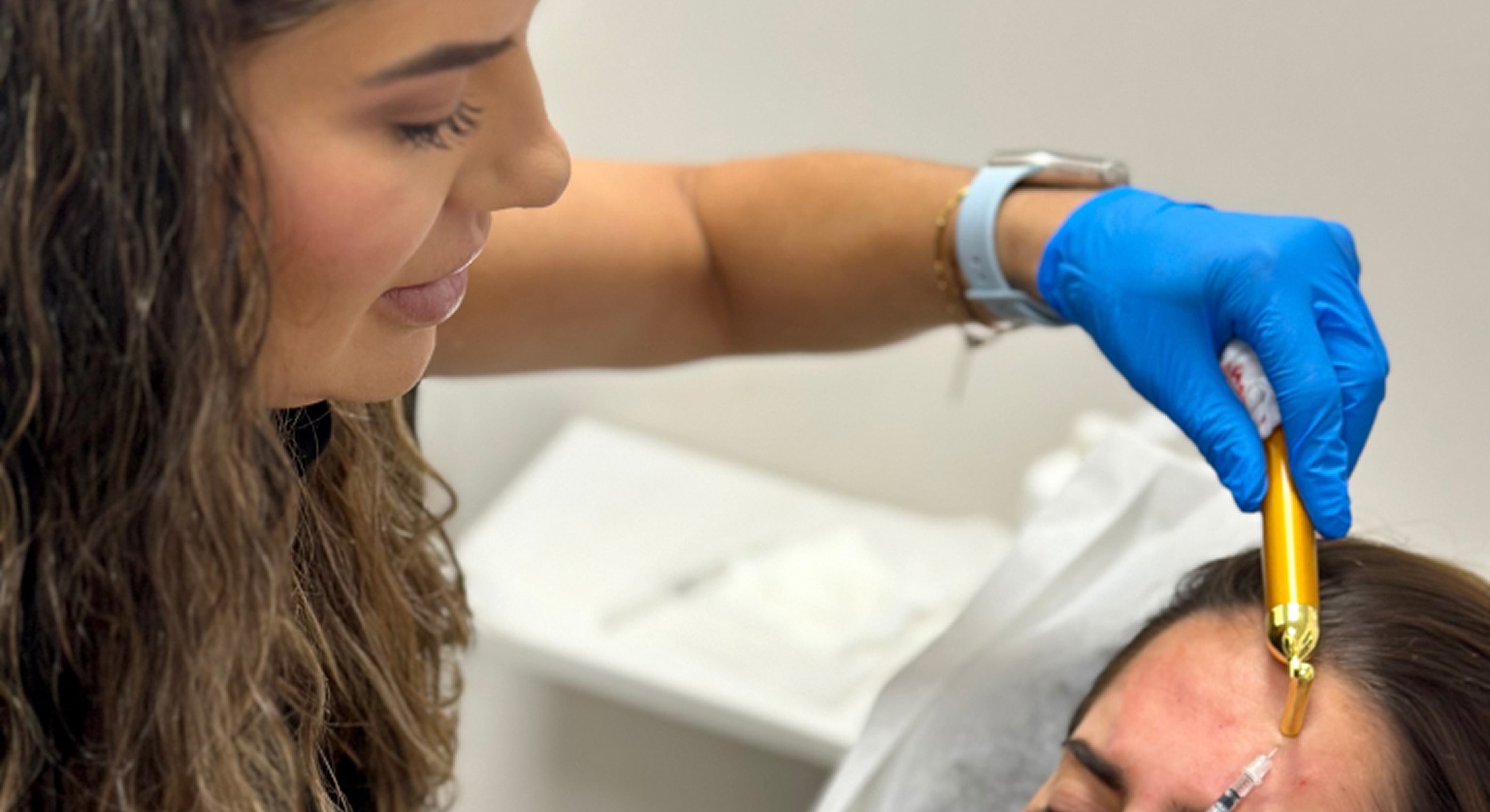 Beauty professional performing skincare treatment on client.