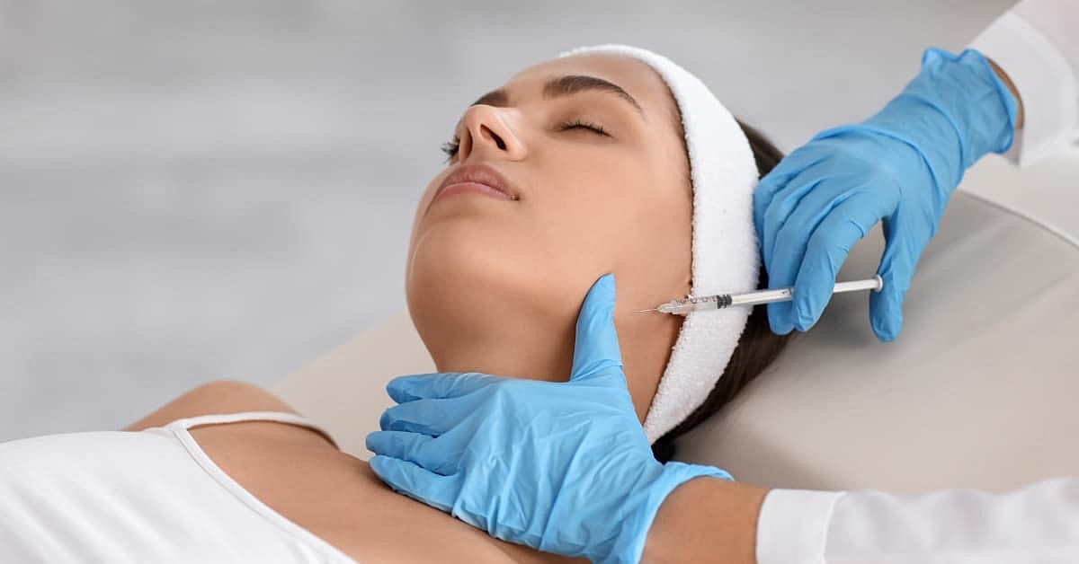 Woman receiving masseter botox injections along her jawline from a gloved provider