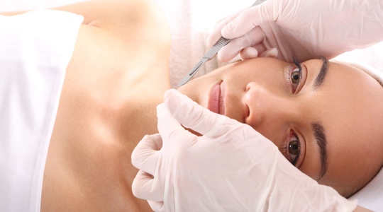Woman receiving dermaplaning treatment at a medspa