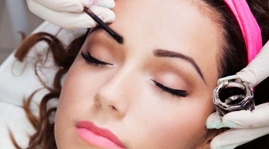 Woman receiving an eyebrow tint treatment at a medspa