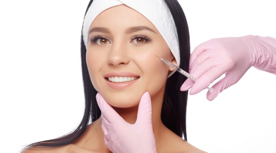 Woman receiving dermal filler injections in her cheeks