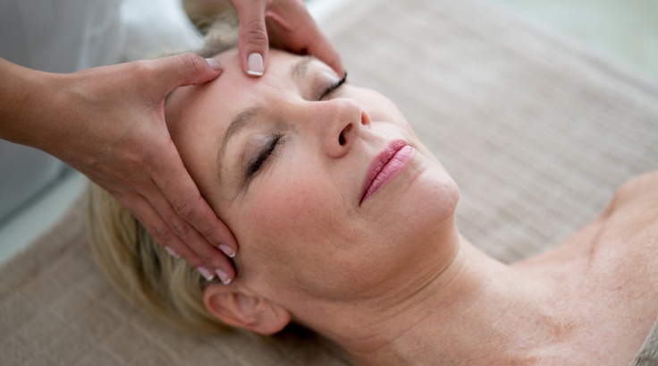 Woman receiving trigger point massage on her forehead