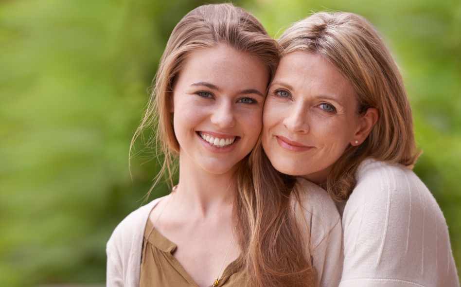 Happy young woman and her mother hugging and smiling